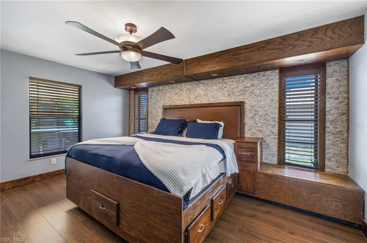 Bedroom with dark hardwood / wood-style flooring and ceiling fan