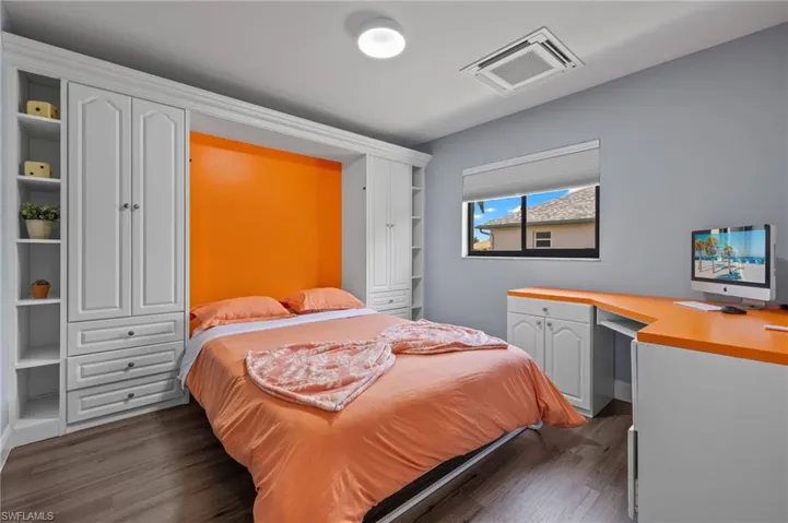 Bedroom with dark hardwood / wood-style flooring