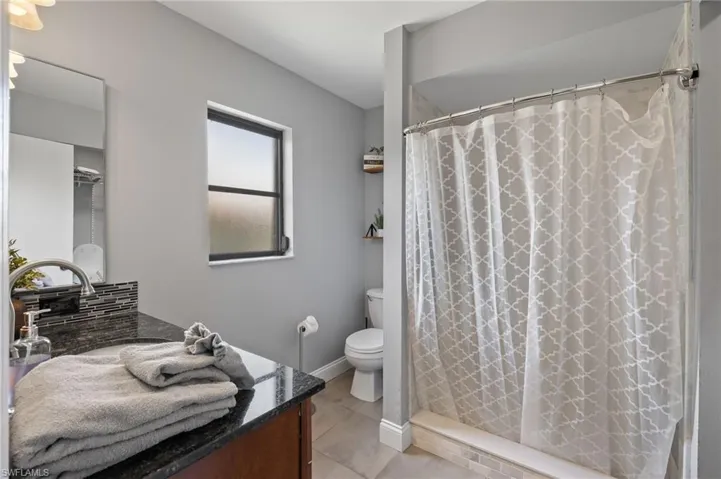 Bathroom featuring tile floors, vanity, and toilet