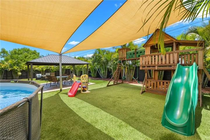 View of jungle gym featuring a lawn and a gazebo