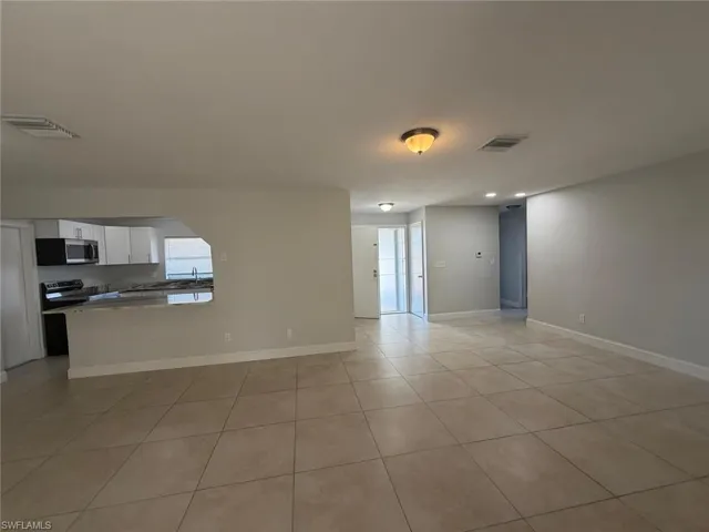 Unfurnished living room with baseboards and light tile patterned floors