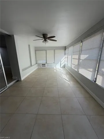 Unfurnished sunroom featuring ceiling fan