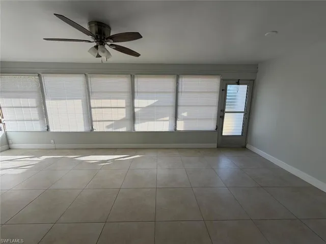 Unfurnished room featuring a ceiling fan and light tile patterned flooring