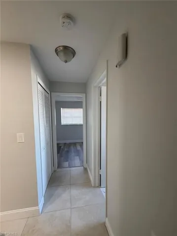 Hallway featuring baseboards and light tile patterned floors