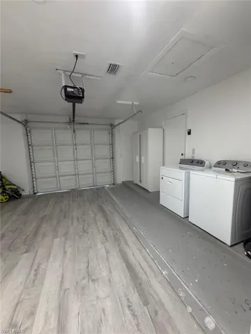 Garage featuring washing machine and clothes dryer and a garage door opener