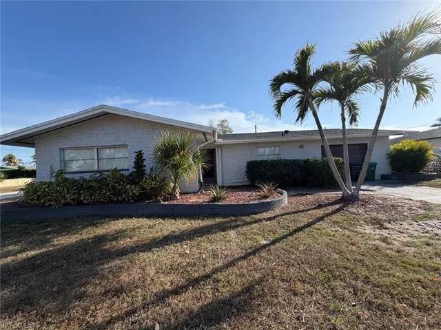 Single story home with brick siding, a garage, a front lawn, and concrete driveway