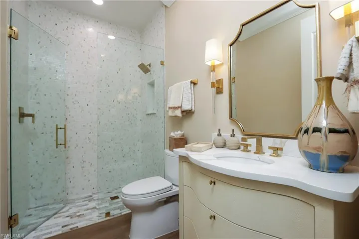 Bathroom with a shower stall, vanity, and wood finished floors