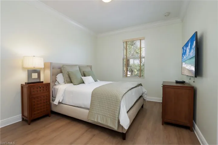 Bedroom with ornamental molding and light wood-style flooring
