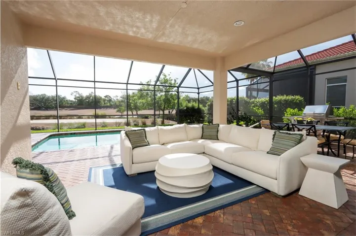 View of patio with outdoor lounge area, an outdoor pool, and glass enclosure