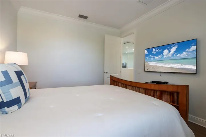 Bedroom featuring ornamental molding and wood finished floors