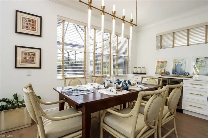 Dining space with dark wood-style flooring and ornamental molding