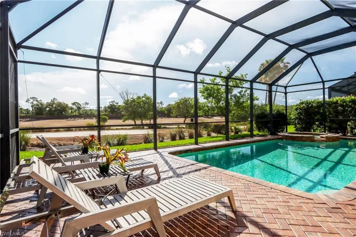 View of swimming pool with a patio, a pool with connected hot tub, and a lanai
