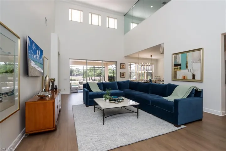 Living room featuring wood finished floors, a high ceiling, and a chandelier