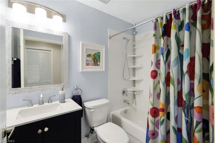 Full bathroom featuring shower / tub combo with curtain, vanity, and toilet
