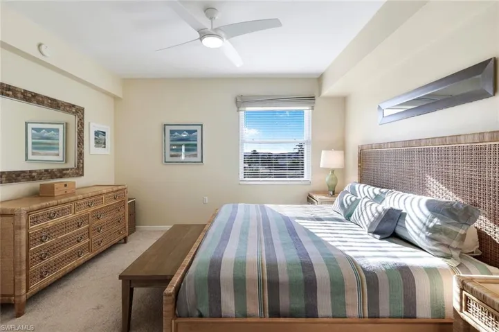 Carpeted bedroom featuring ceiling fan