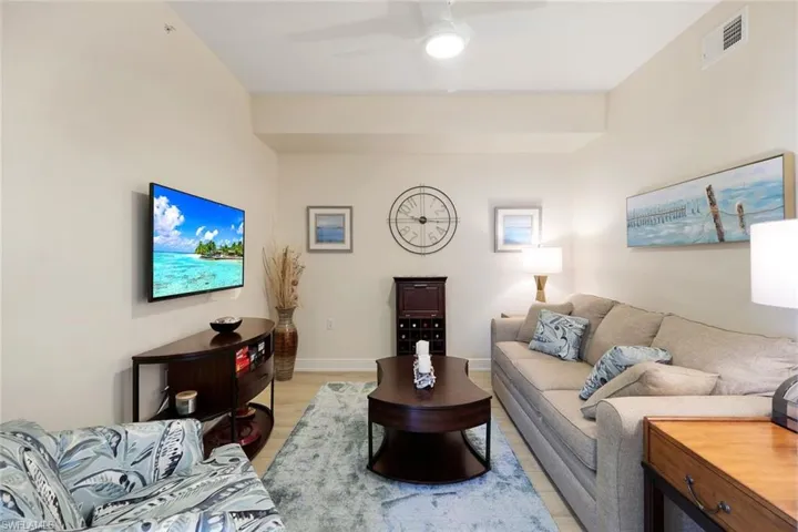 Living room with ceiling fan and light hardwood / wood-style floors