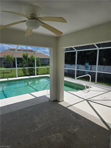 View of swimming pool featuring a patio, a lanai, and a ceiling fan