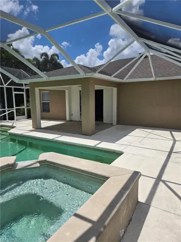 View of swimming pool with a patio area, a lanai, and a pool with connected hot tub