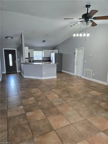 Empty room with a ceiling fan and lofted ceiling