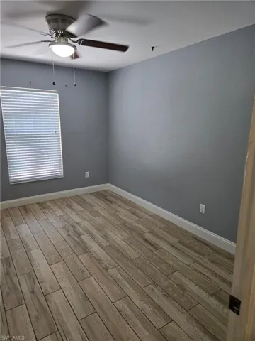 Empty room with a ceiling fan and wood finished floors