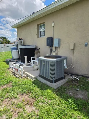 Exterior view of a central AC unit and stucco siding