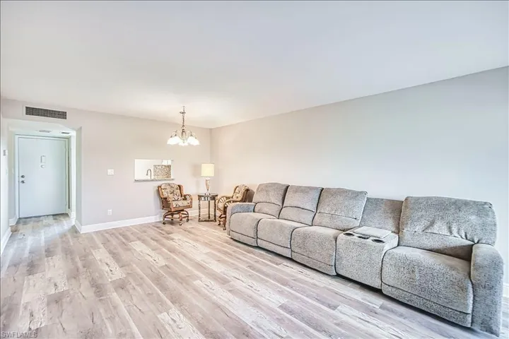 Living room with a chandelier and light wood-style flooring