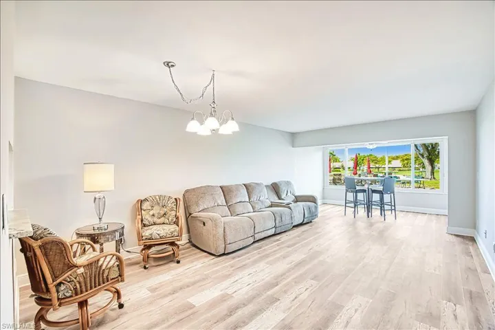 Living area with light wood-style floors and hanging lights