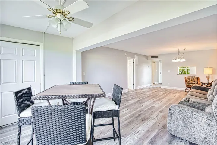 Dining space with light wood-style flooring, ceiling fan, and a chandelier