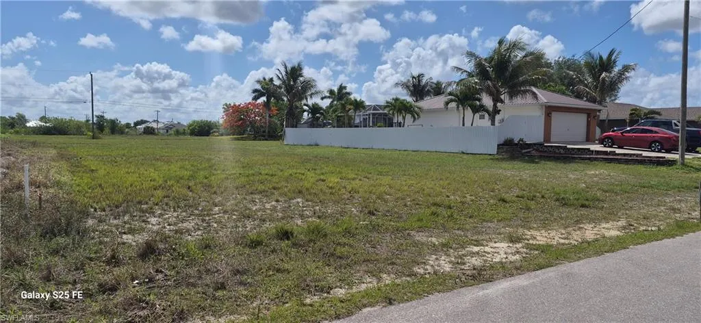 Expansive vacant lot featuring grass and sparse vegetation