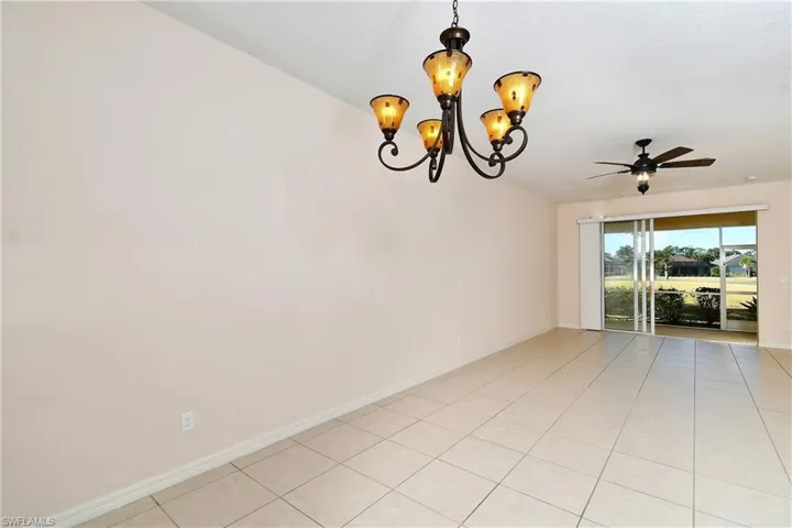 Empty room featuring suspended lighting, a ceiling fan, and light tile patterned floors