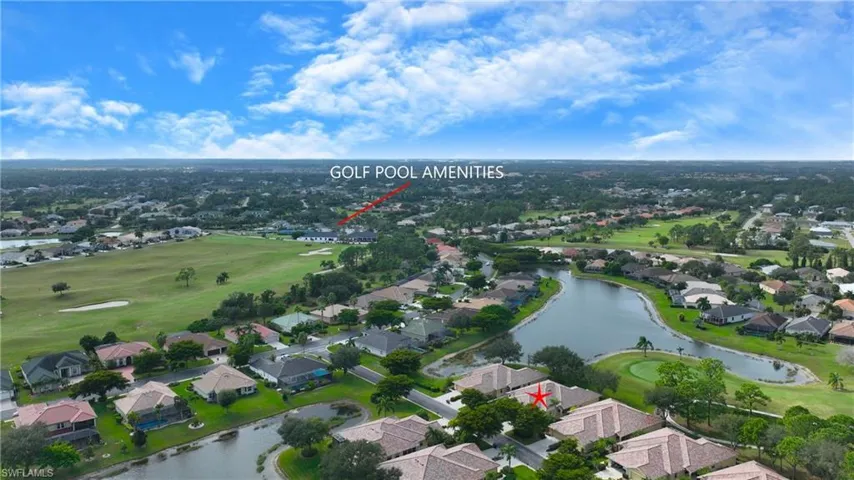 Aerial view of residential area featuring a golf course and a large body of water
