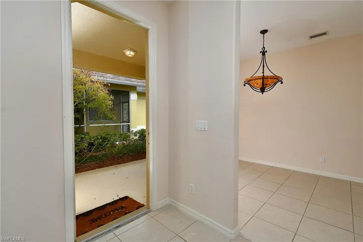 Entryway with light tile patterned floors and baseboards