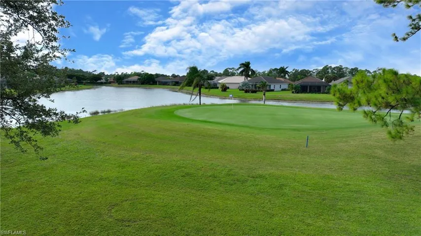 Surrounding community with a water view, a residential view, and a putting area