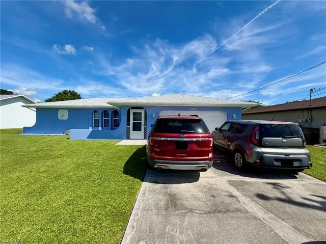 Stucco exterior with a white entry door, an attached garage, and a concrete driveway