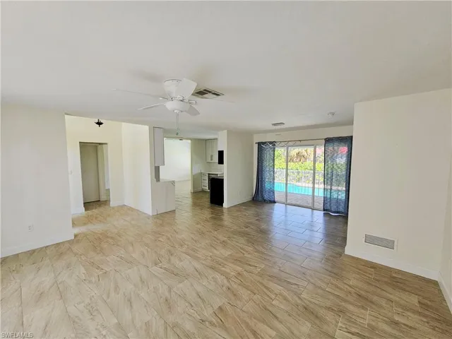 Unfurnished living room with ceiling fan and baseboards