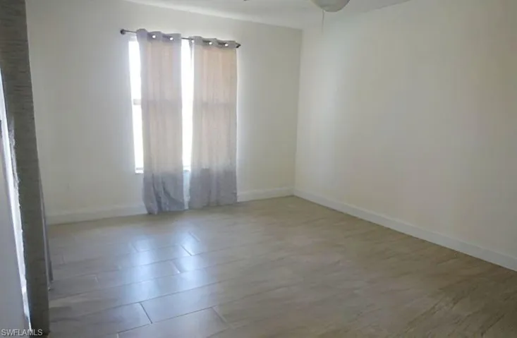 Empty room featuring baseboards and light wood-style flooring