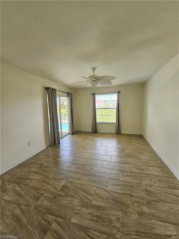 Unfurnished room with baseboards and ceiling fan