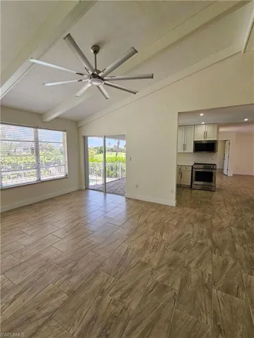 Unfurnished living room with baseboards and a ceiling fan