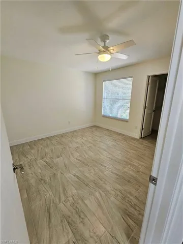 Unfurnished bedroom featuring a ceiling fan and a walk in closet