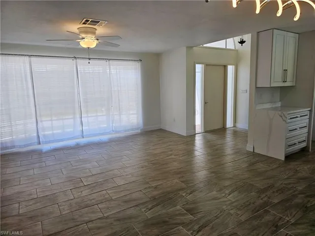 Unfurnished living room featuring baseboards and ceiling fan