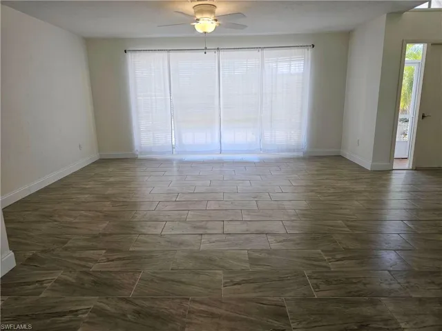 Empty room with healthy amount of natural light and a ceiling fan