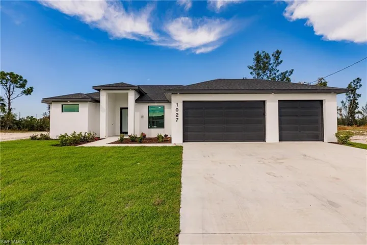 View of front of house featuring a front lawn and a garage