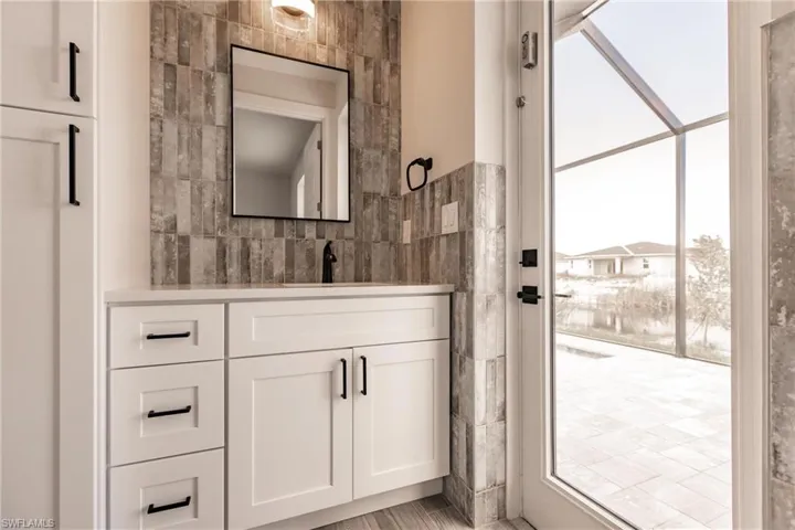 Bathroom with vanity and tile walls