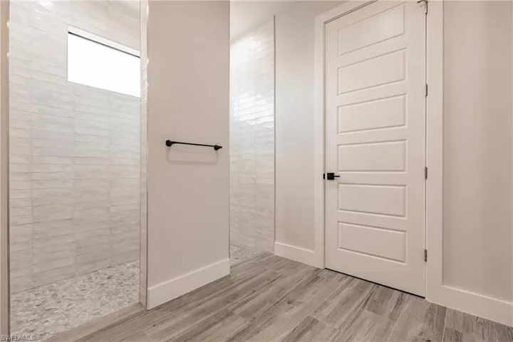 Bathroom with hardwood / wood-style flooring and a tile shower