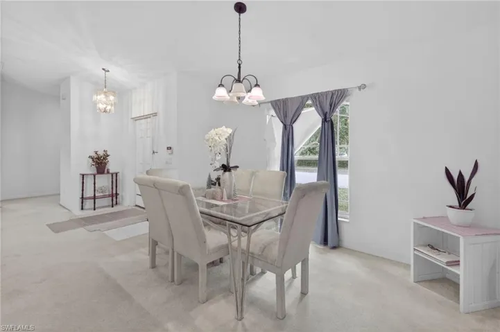 Dining space featuring light colored carpet and baseboards