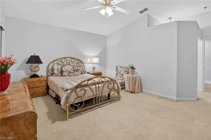 Bedroom with light carpet, lofted ceiling, and ceiling fan