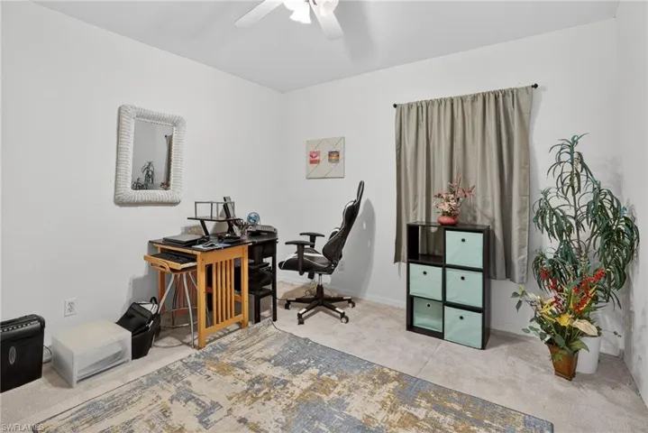 Office area with carpet flooring and a ceiling fan