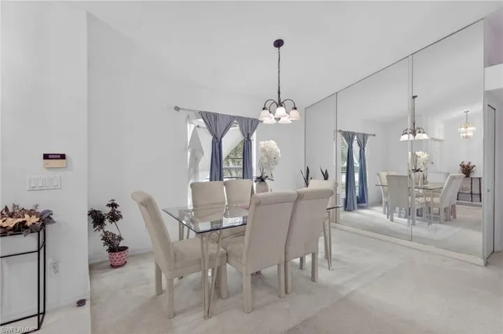 Dining area featuring light colored carpet and a chandelier