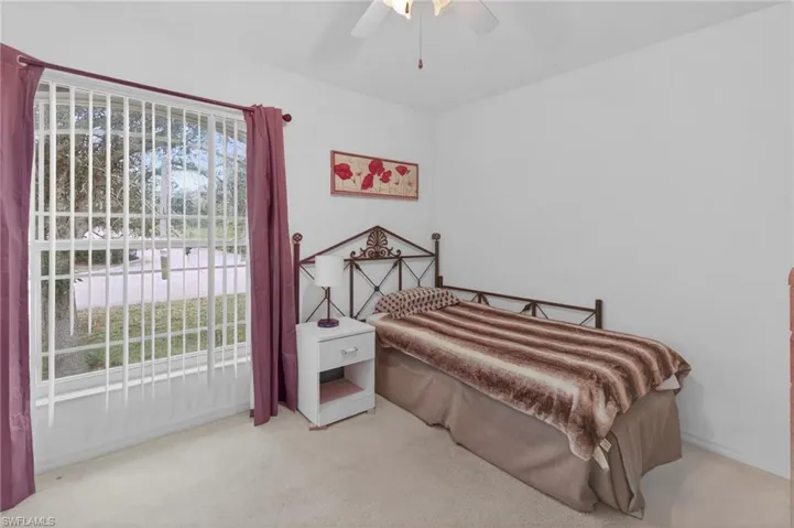 Bedroom featuring light colored carpet and a ceiling fan