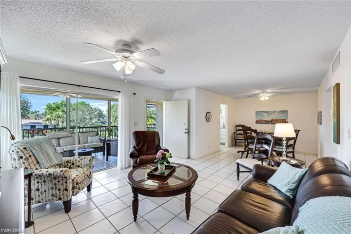 Living area with tile patterned floors, ceiling fan, and a textured ceiling
